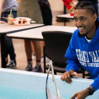 A student prepares to race his boat